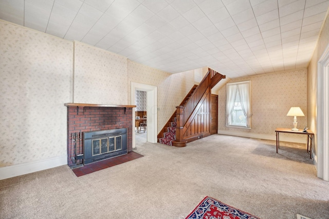 carpeted living room featuring wallpapered walls, stairs, baseboards, and a fireplace