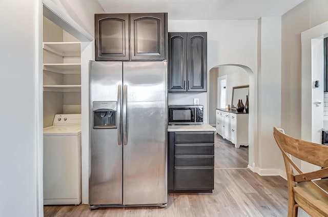 kitchen featuring dark brown cabinetry, washer / dryer, stainless steel appliances, and light hardwood / wood-style floors