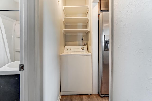 laundry area with washer / clothes dryer and light hardwood / wood-style flooring