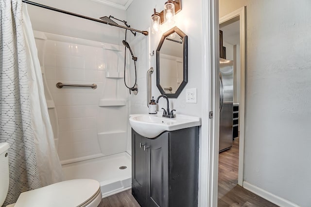 bathroom with wood-type flooring, vanity, walk in shower, and toilet