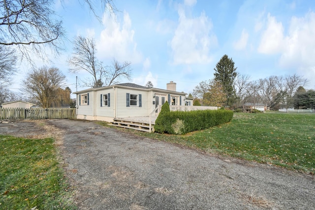 view of front of home featuring a front yard and a deck