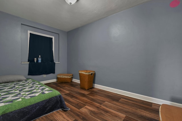 bedroom with dark wood-type flooring