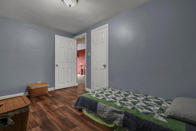 bedroom with dark hardwood / wood-style flooring