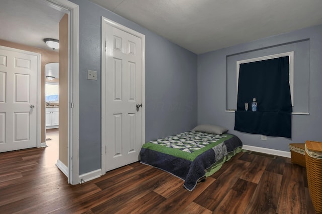 bedroom with dark hardwood / wood-style floors