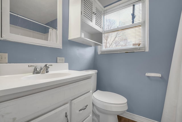 bathroom featuring a shower with shower curtain, vanity, a healthy amount of sunlight, and toilet