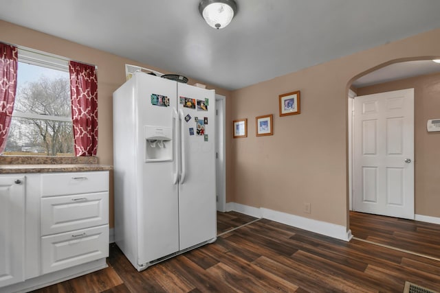 kitchen featuring dark hardwood / wood-style floors, white cabinetry, and white fridge with ice dispenser