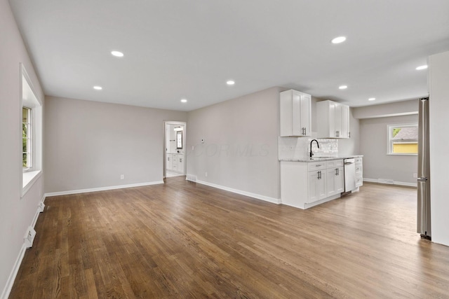 unfurnished living room featuring hardwood / wood-style floors and sink