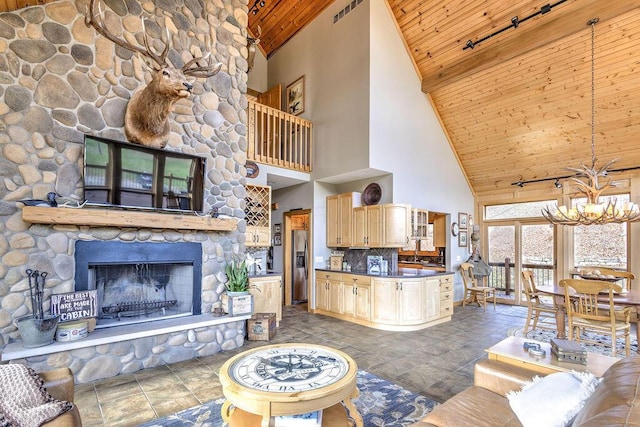 living room with a stone fireplace, a chandelier, high vaulted ceiling, and wooden ceiling