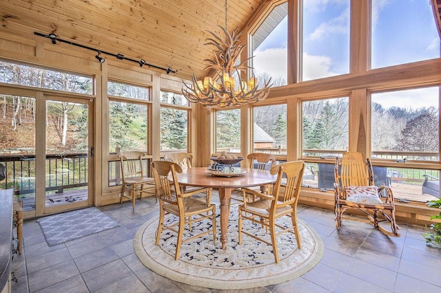 sunroom featuring plenty of natural light, vaulted ceiling, wooden ceiling, and a chandelier