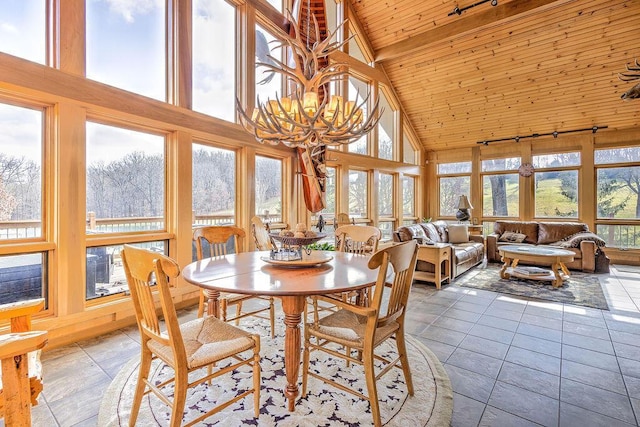 sunroom with vaulted ceiling with beams, a wealth of natural light, and a chandelier