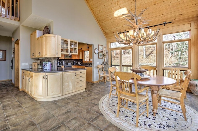 kitchen with wooden ceiling, high vaulted ceiling, hanging light fixtures, light brown cabinetry, and a chandelier