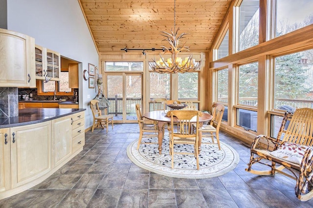 dining space featuring wood ceiling, plenty of natural light, high vaulted ceiling, and a chandelier