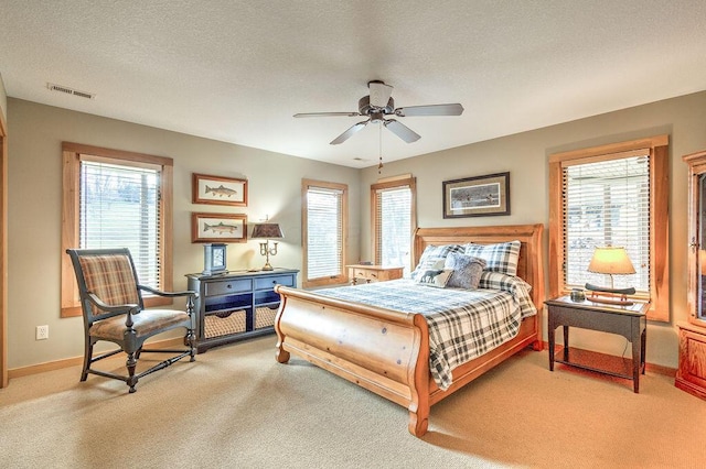 carpeted bedroom featuring ceiling fan and a textured ceiling