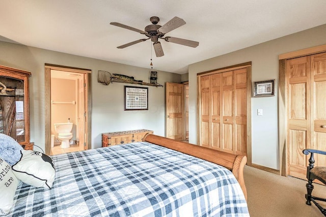 bedroom featuring ceiling fan, ensuite bathroom, light carpet, and multiple closets