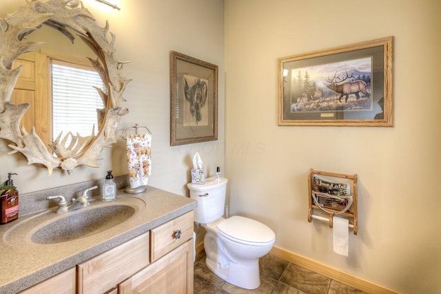 bathroom with tile patterned flooring, vanity, and toilet