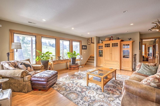 living room featuring light hardwood / wood-style flooring and a textured ceiling