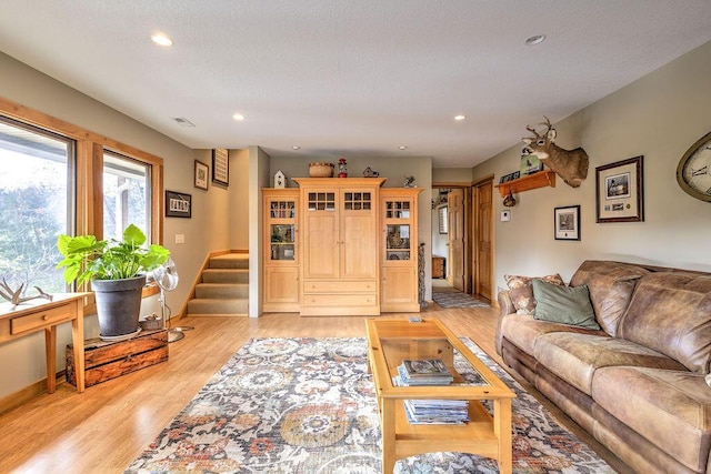 living room featuring light hardwood / wood-style floors and a textured ceiling