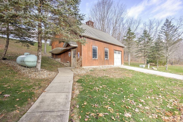 exterior space with a garage and a lawn