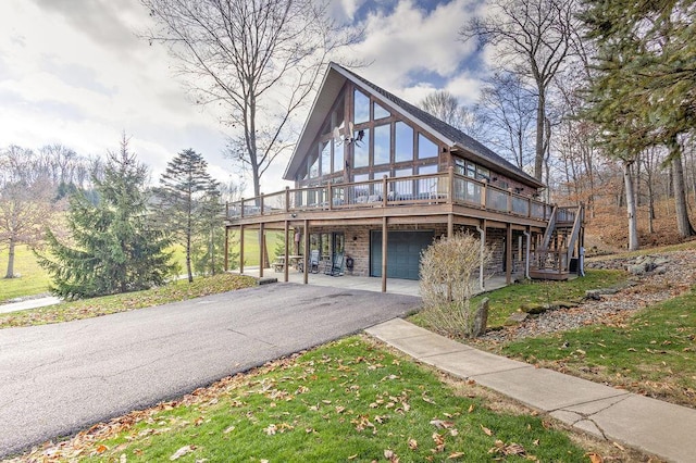 view of front facade with a front yard, a deck, and a garage