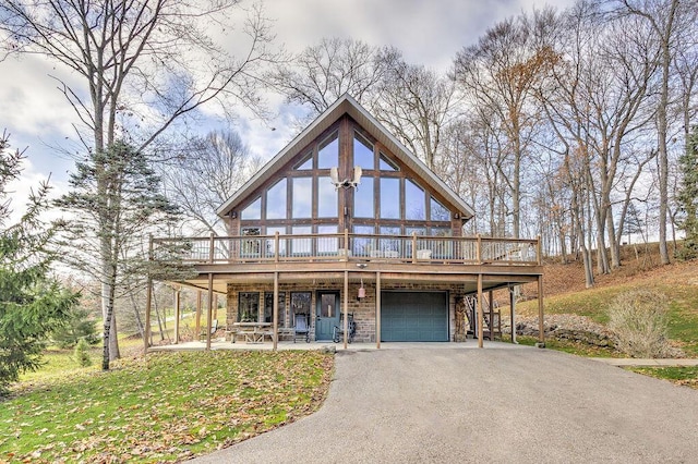 view of front of property with a patio area, a garage, a wooden deck, and a front lawn