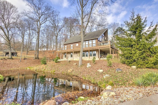 rear view of house featuring a deck with water view