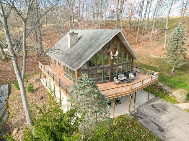 view of front of home featuring a sunroom, a garage, and a wooden deck