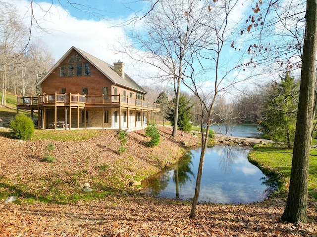 back of property featuring a deck with water view