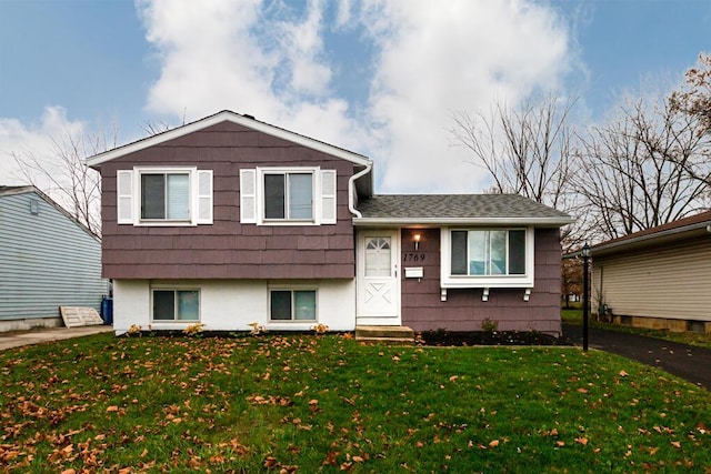 tri-level home with a front lawn