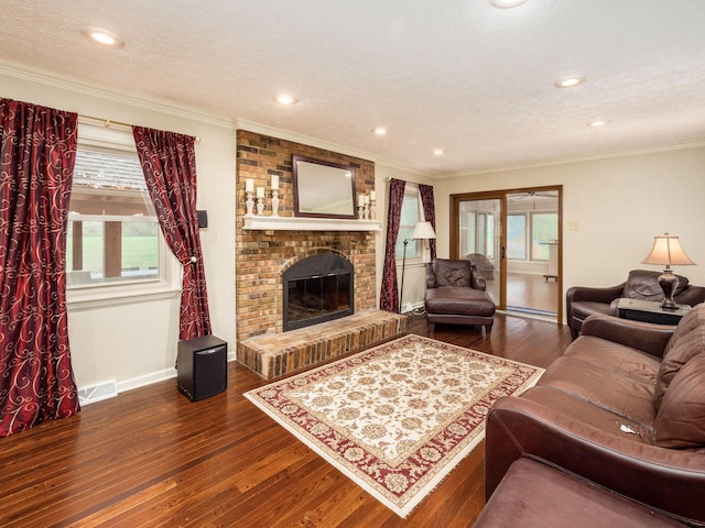 living room featuring a textured ceiling, a fireplace, crown molding, and dark wood-type flooring