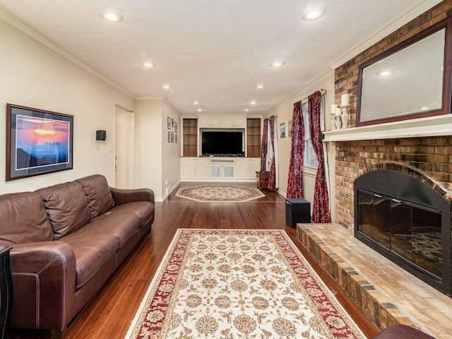 living room featuring a fireplace, wood-type flooring, a textured ceiling, and ornamental molding