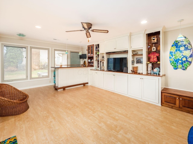 living room featuring ceiling fan, ornamental molding, and light hardwood / wood-style flooring