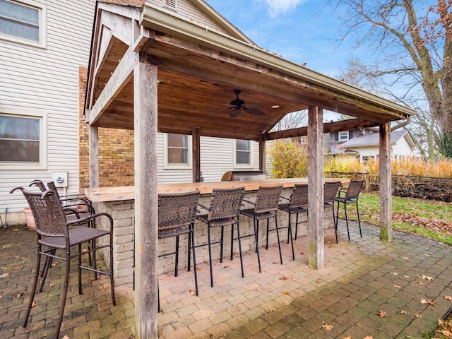 view of patio / terrace with ceiling fan and an outdoor bar