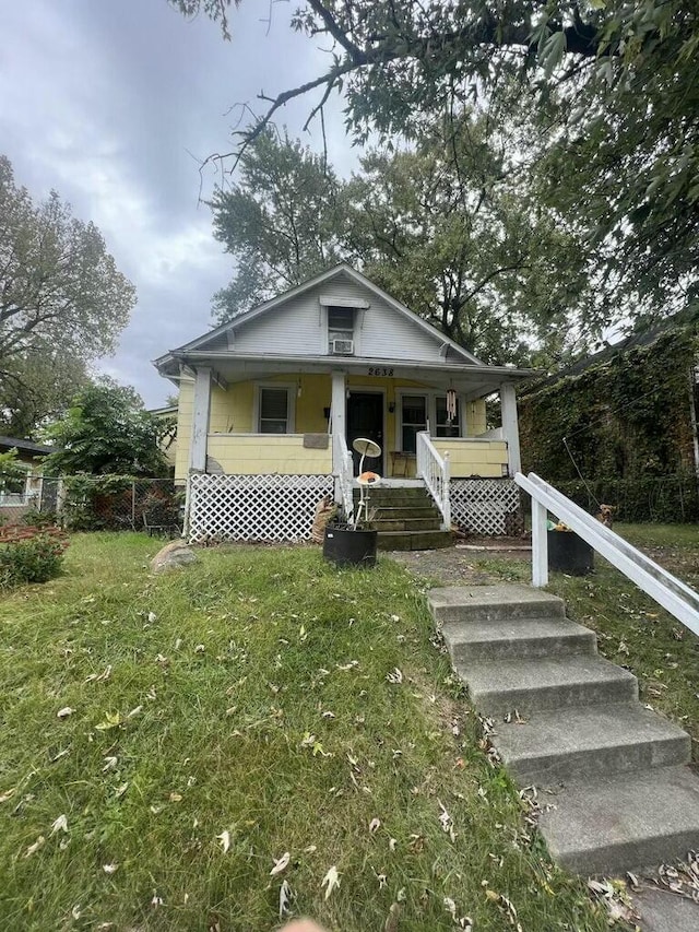 bungalow-style house with a front lawn and covered porch