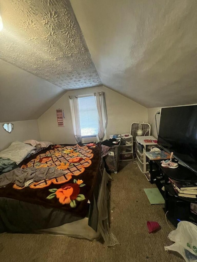 bedroom with carpet flooring, a textured ceiling, and vaulted ceiling