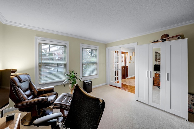 sitting room with french doors, a textured ceiling, light colored carpet, and crown molding