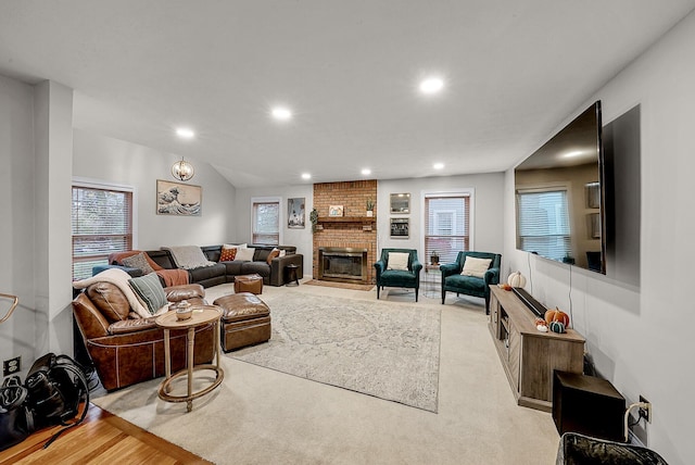 living room featuring a fireplace, light hardwood / wood-style floors, and a healthy amount of sunlight