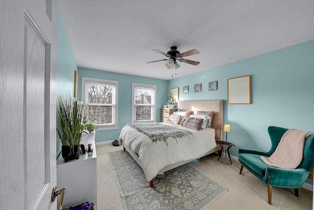 carpeted bedroom featuring ceiling fan and a textured ceiling