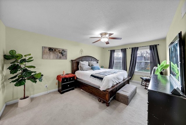 carpeted bedroom featuring ceiling fan and a textured ceiling