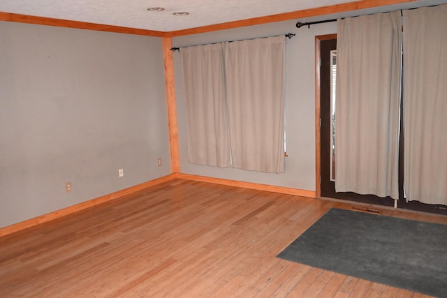 spare room featuring light hardwood / wood-style floors and a textured ceiling