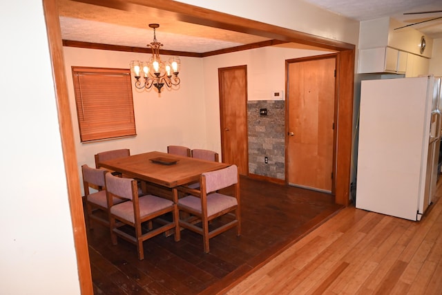 dining space with a notable chandelier and light hardwood / wood-style flooring