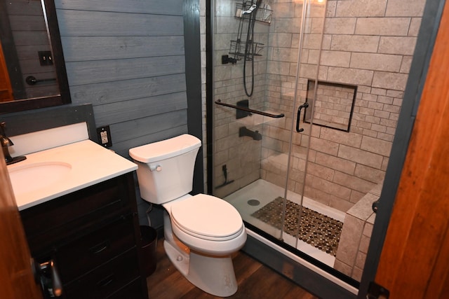 bathroom with hardwood / wood-style flooring, vanity, toilet, and walk in shower