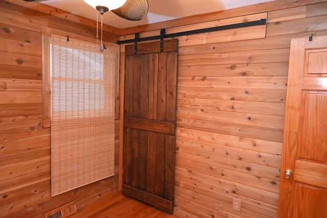 bathroom with hardwood / wood-style floors and wood walls