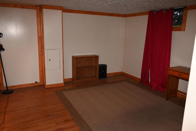 spare room featuring hardwood / wood-style floors and a textured ceiling