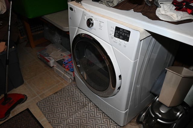 laundry room featuring washer / dryer and dark tile patterned floors