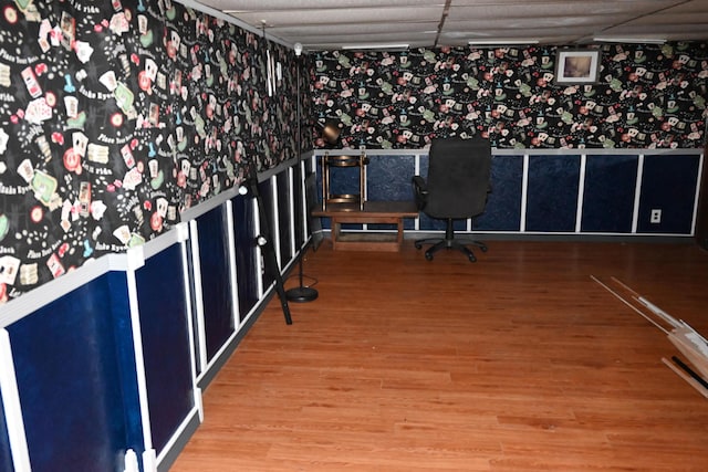 unfurnished office featuring a paneled ceiling and wood-type flooring