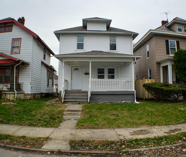 view of property featuring covered porch and a front yard