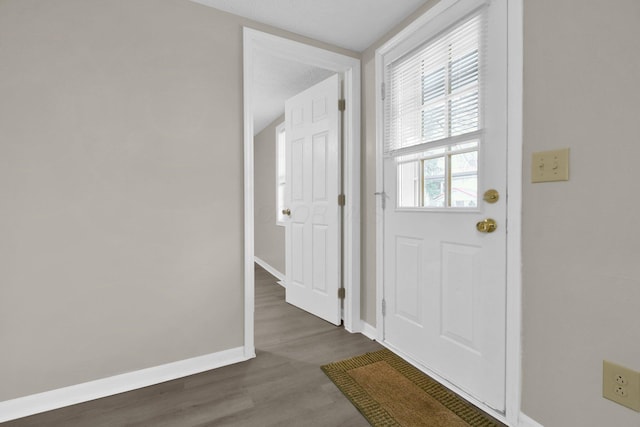 foyer entrance with dark hardwood / wood-style flooring and a textured ceiling