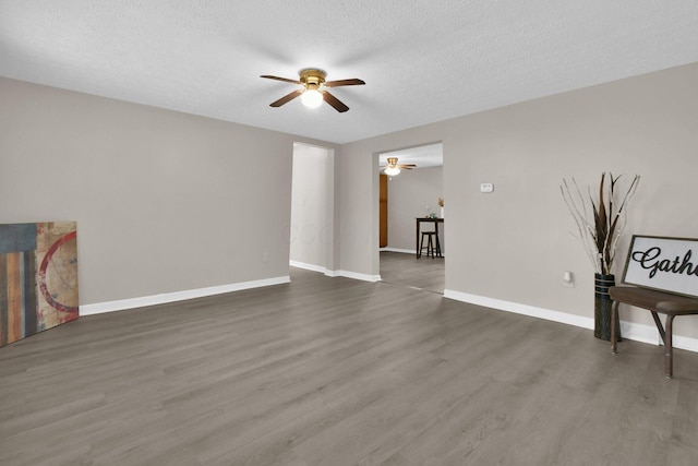 living room featuring a textured ceiling, ceiling fan, and dark wood-type flooring