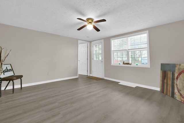 living room with a textured ceiling, dark hardwood / wood-style floors, and ceiling fan