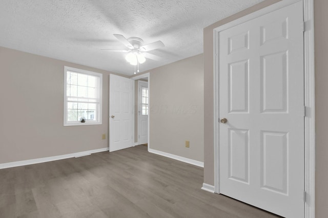 empty room with ceiling fan, hardwood / wood-style floors, and a textured ceiling